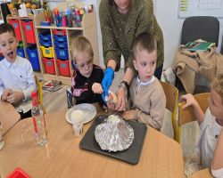 dzieci słuchają opowiadania czytanego przez mamę