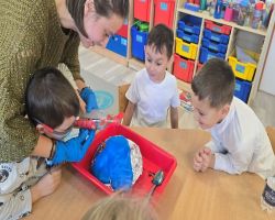 dzieci słuchają opowiadania czytanego przez mamę