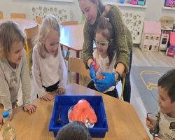 dzieci słuchają opowiadania czytanego przez mamę