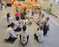 dzieci słuchają opowiadania czytanego przez mamę