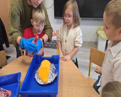 dzieci słuchają opowiadania czytanego przez mamę