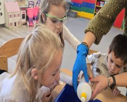 dzieci słuchają opowiadania czytanego przez mamę