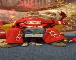 dzieci podczas spotkania ze Świętym Mikołajem i Panią Mikołajową, otrzymują prezenty i śpiewają piosenki