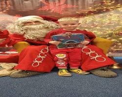 dzieci podczas spotkania ze Świętym Mikołajem i Panią Mikołajową, otrzymują prezenty i śpiewają piosenki