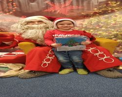 dzieci podczas spotkania ze Świętym Mikołajem i Panią Mikołajową, otrzymują prezenty i śpiewają piosenki