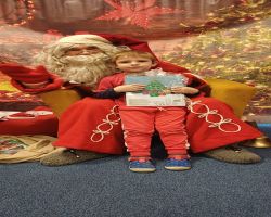 dzieci podczas spotkania ze Świętym Mikołajem i Panią Mikołajową, otrzymują prezenty i śpiewają piosenki