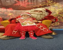 dzieci podczas spotkania ze Świętym Mikołajem i Panią Mikołajową, otrzymują prezenty i śpiewają piosenki