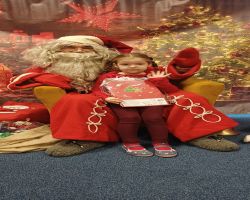 dzieci podczas spotkania ze Świętym Mikołajem i Panią Mikołajową, otrzymują prezenty i śpiewają piosenki