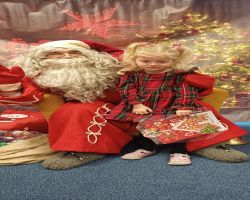 dzieci podczas spotkania ze Świętym Mikołajem i Panią Mikołajową, otrzymują prezenty i śpiewają piosenki