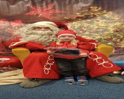 dzieci podczas spotkania ze Świętym Mikołajem i Panią Mikołajową, otrzymują prezenty i śpiewają piosenki