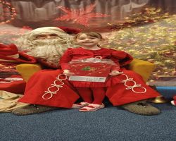 dzieci podczas spotkania ze Świętym Mikołajem i Panią Mikołajową, otrzymują prezenty i śpiewają piosenki