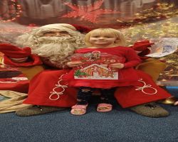 dzieci podczas spotkania ze Świętym Mikołajem i Panią Mikołajową, otrzymują prezenty i śpiewają piosenki