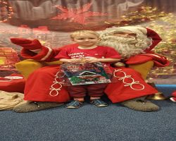 dzieci podczas spotkania ze Świętym Mikołajem i Panią Mikołajową, otrzymują prezenty i śpiewają piosenki