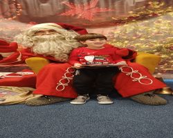 dzieci podczas spotkania ze Świętym Mikołajem i Panią Mikołajową, otrzymują prezenty i śpiewają piosenki