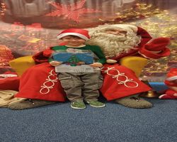 dzieci podczas spotkania ze Świętym Mikołajem i Panią Mikołajową, otrzymują prezenty i śpiewają piosenki