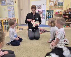 dzieci, teraputa i psy podczas zajęć dogoterapii w przedszkolu