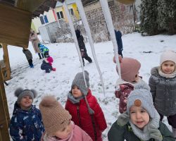 Dzieci bawią się na dworze, jest słoneczne zimowe przedpołudnie