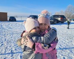 Dzieci bawią się na dworze, jest słoneczne zimowe przedpołudnie