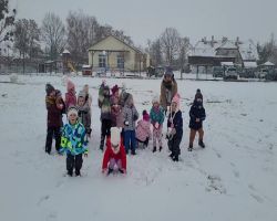 Dzieci bawią się na dworze, jest słoneczne zimowe przedpołudnie