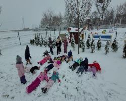 Dzieci bawią się na dworze, jest słoneczne zimowe przedpołudnie