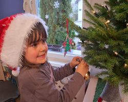 Dzieci ubierają choinkę na święta