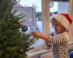 Dzieci ubierają choinkę na święta