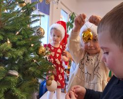 Dzieci ubierają choinkę na święta