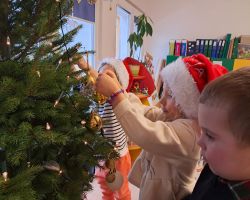 Dzieci ubierają choinkę na święta