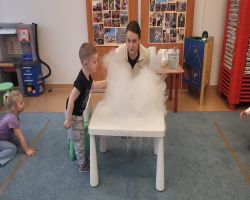 Dzieci uczestniczą w zajęciach poświęconych eksperymentom z suchym lodem