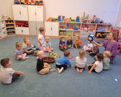 Dzieci przeliczają elementy rozłożone na dywanie