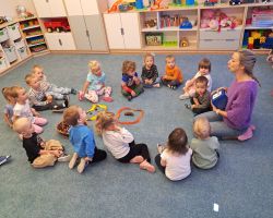 Dzieci przeliczają elementy rozłożone na dywanie