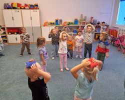 Dzieci przeliczają elementy rozłożone na dywanie