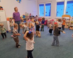 Dzieci przeliczają elementy rozłożone na dywanie