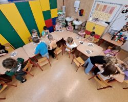 Dzieci ozdabiają wypieczone pierniki kolorowymi posypkami