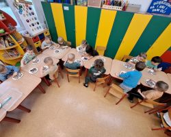 Dzieci ozdabiają wypieczone pierniki kolorowymi posypkami