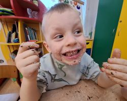 Dzieci ozdabiają wypieczone pierniki kolorowymi posypkami