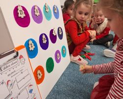 Dzieci otwierają okienka w kalendarzu adwentowym