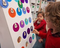 Dzieci otwierają okienka w kalendarzu adwentowym