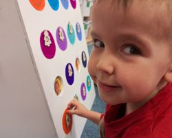 Dzieci otwierają okienka w kalendarzu adwentowym