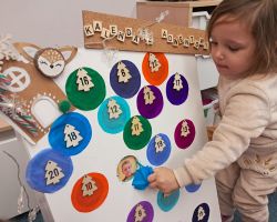 Dzieci otwierają okienka w kalendarzu adwentowym