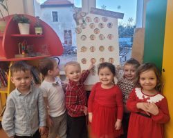 Dzieci otwierają okienka w kalendarzu adwentowym