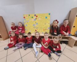 Dzieci ozdabiają plakat kolorowymi kołami origami