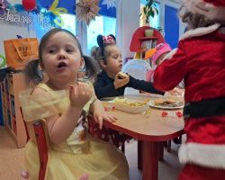 dzieci przebrane za postacie z bajek tancza na balu, pozuja do zdjecia grupowego, jedza poczestunek