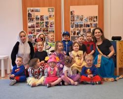 dzieci przebrane za postacie z bajek tancza na balu, pozuja do zdjecia grupowego, jedza poczestunek