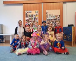 dzieci przebrane za postacie z bajek tancza na balu, pozuja do zdjecia grupowego, jedza poczestunek