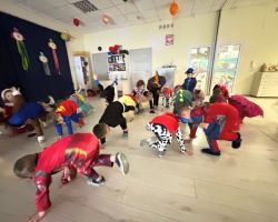 dzieci przebrane za postacie z bajek tancza na balu, pozuja do zdjecia grupowego, jedza poczestunek