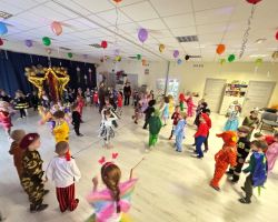 dzieci przebrane za postacie z bajek tancza na balu, pozuja do zdjecia grupowego, jedza poczestunek