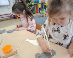 dzieci wykonujące aniołki z gliny