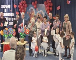 dzieci występują na scenie, pozują do zdjęć z dziadkami