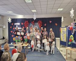 dzieci występują na scenie, pozują do zdjęć z dziadkami